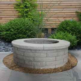 Promenade sandstone fire pit kit in cool gray tones, durable natural stone design for stylish patios and year‑round outdoor enjoyment.