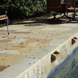 Enhance your patio with beautiful stone pavers and coping, providing durability and style for a perfect outdoor space to relax and entertain.