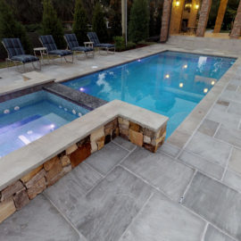 Promenade Classicstone pavers paired with sandstone copings, featuring soft gray tones for a contemporary patio and pool deck installation.